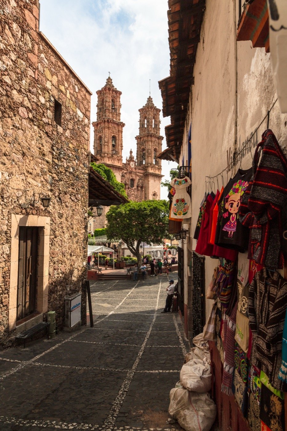 A narrow cobbled street in Taxco with artisan clothes for sale