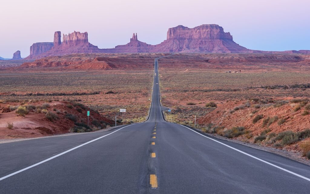 An empty highway curving through red rock country in the American southwest