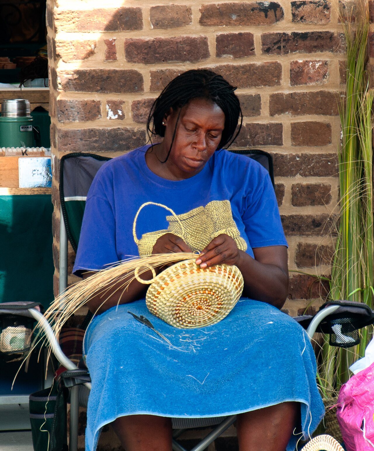 A Gullah artist weaving a sweetgrass basket