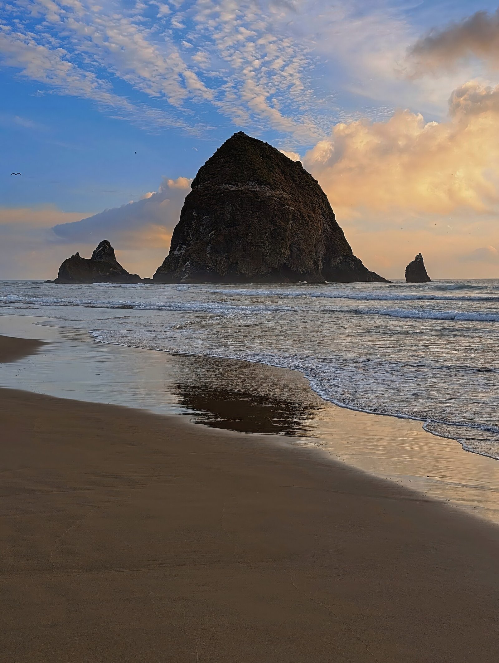 Haystack Rock rising from the sand at Cannon Beach, Oregon