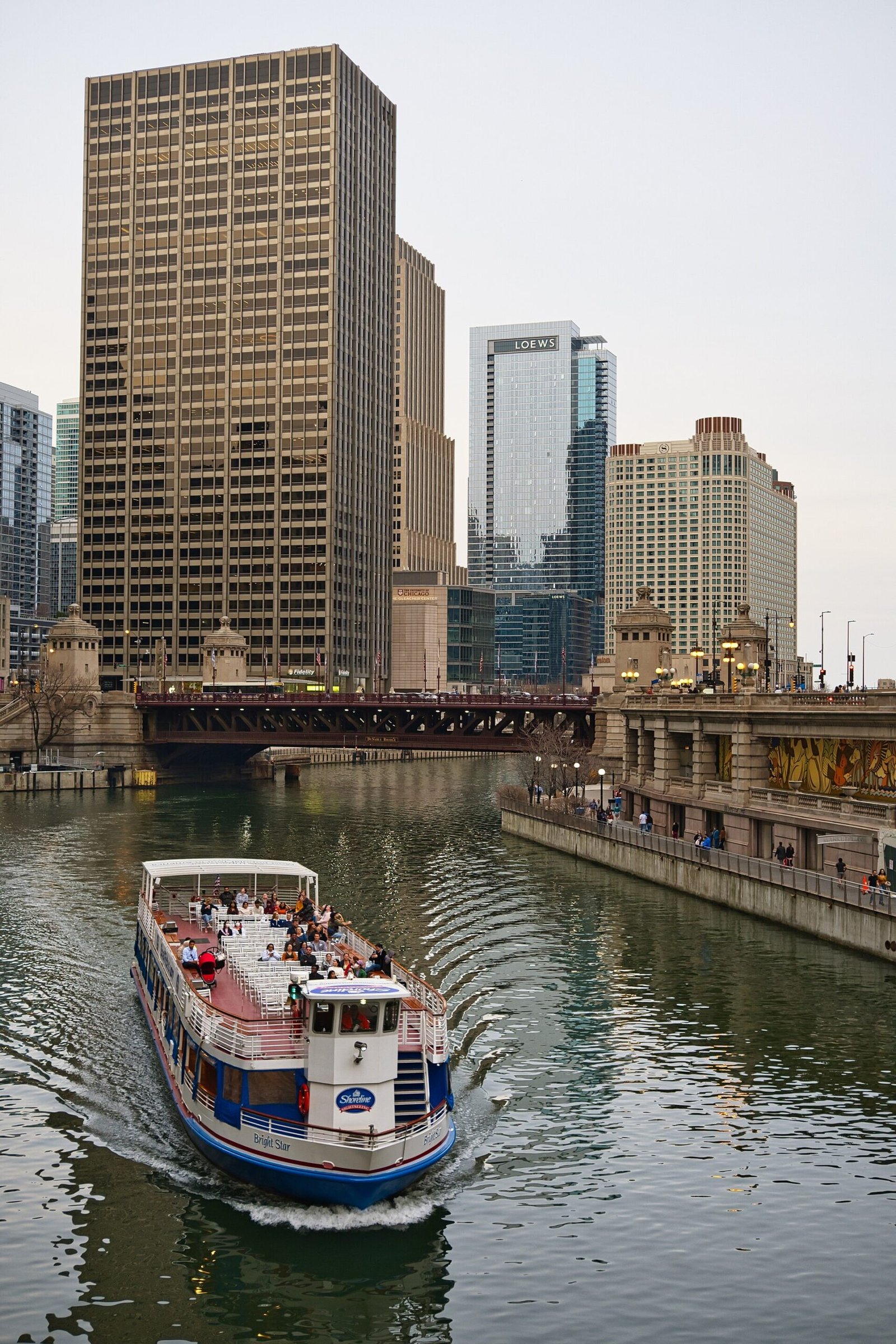 A sightseeing boat on the Chicago River between skyscrapers
