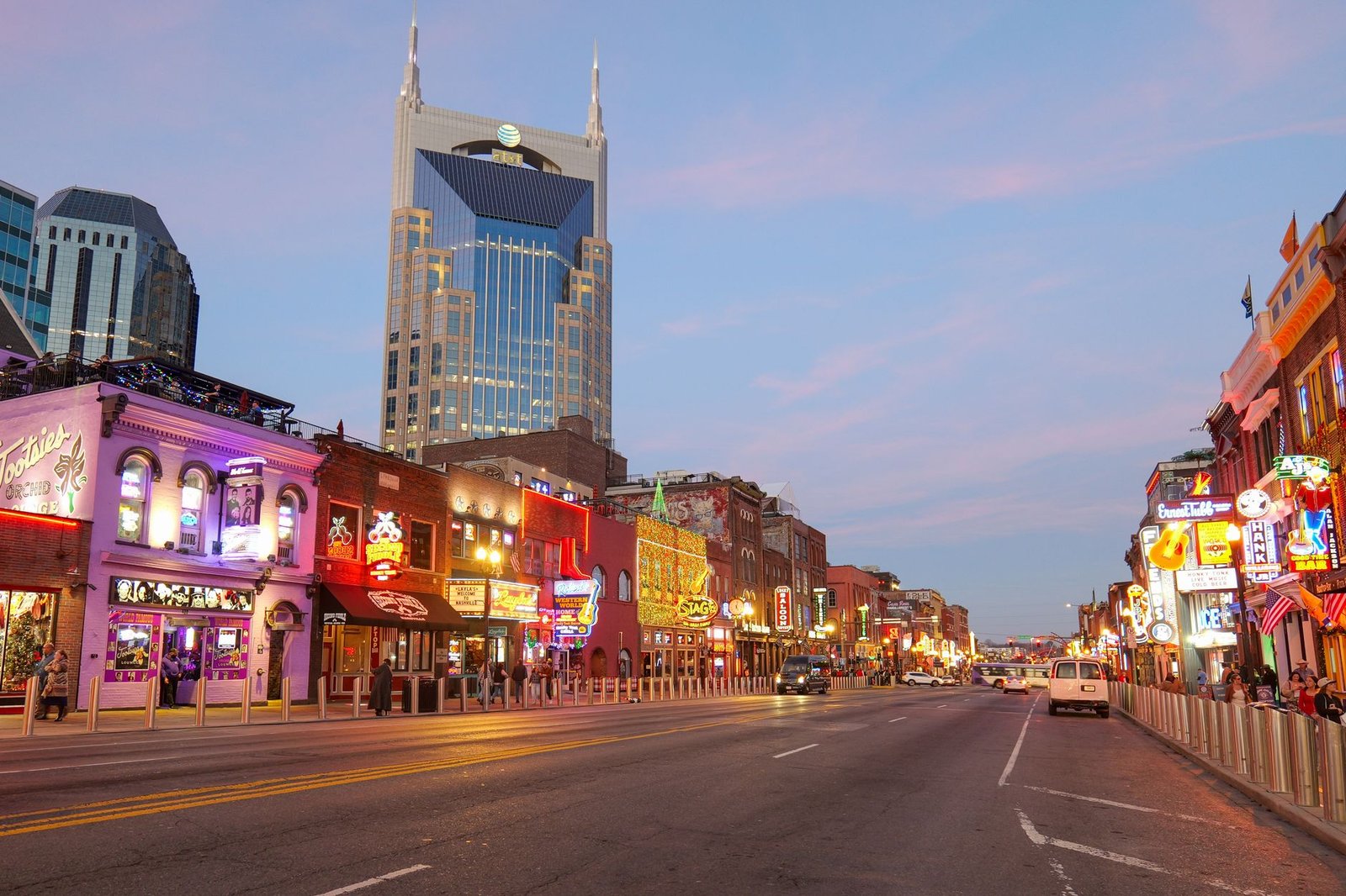 Neon signs lighting up Lower Broadway in downtown Nashville at dusk