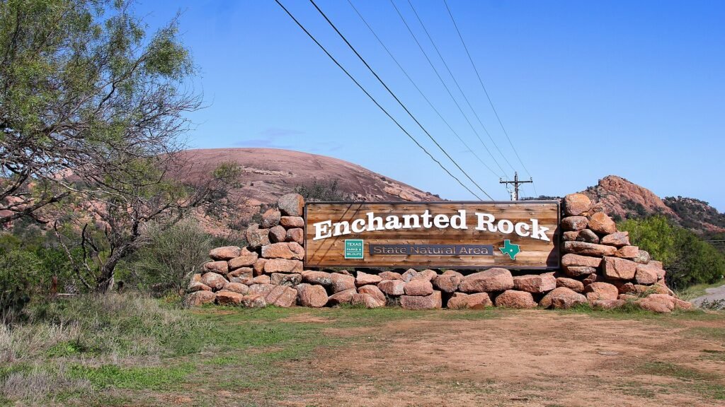 The entrance to Enchanted Rock State Natural Area, with the granite dome behind