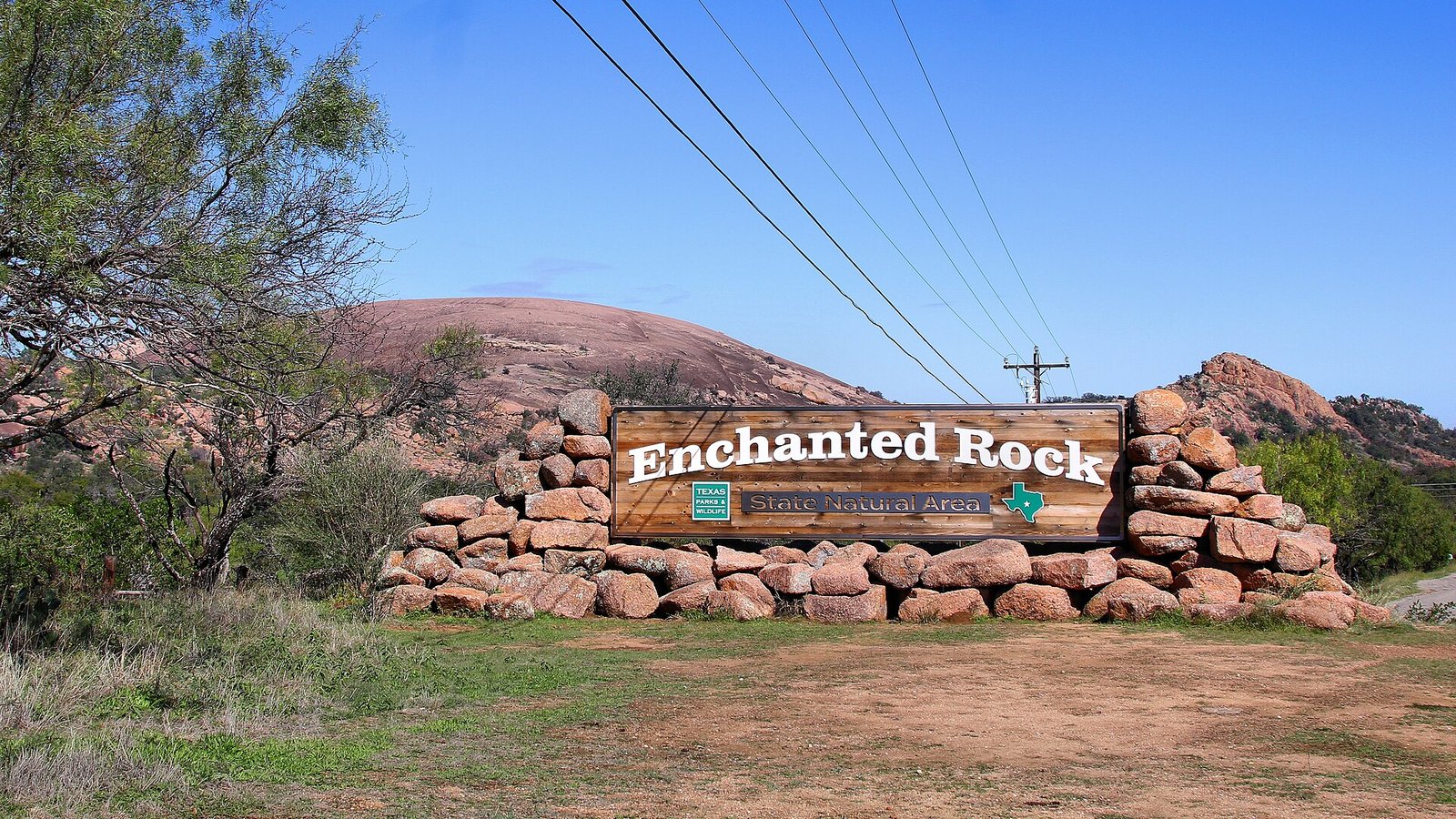 The entrance to Enchanted Rock State Natural Area, with the granite dome behind